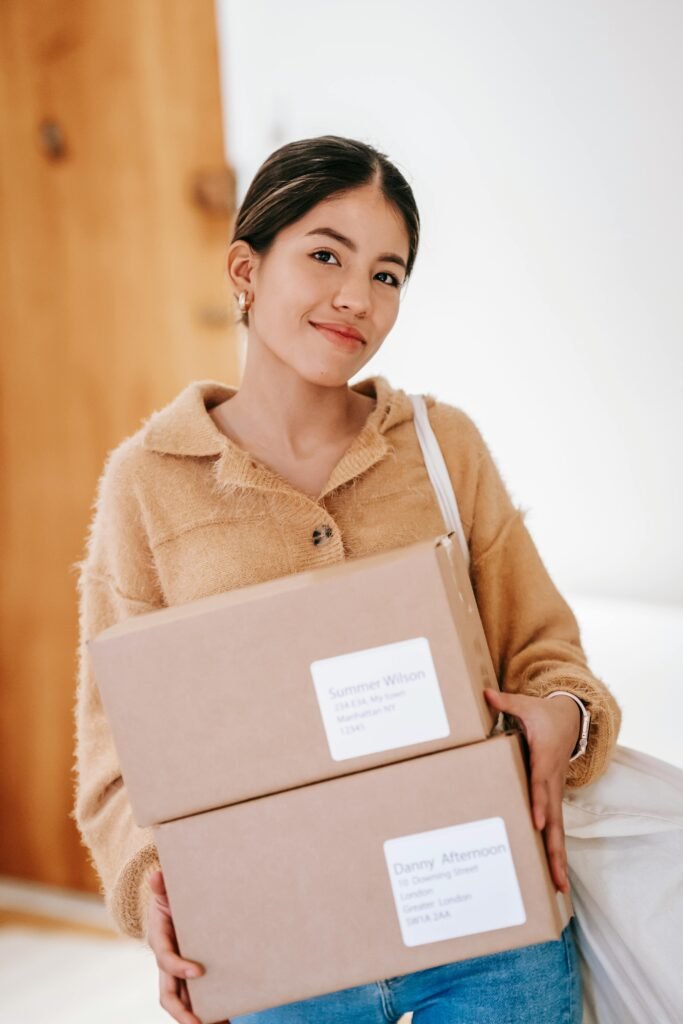 Smiling ethnic woman carrying cardboard parcels